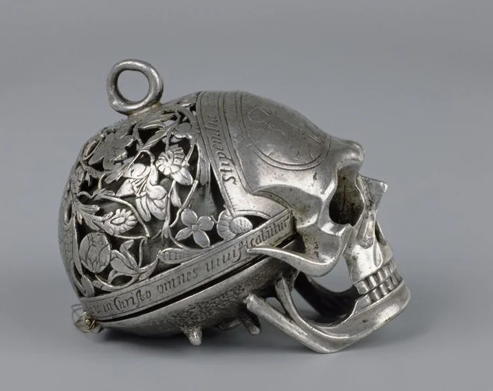 Memento mori skull watch, known as the “Mary, Queen of Scots” watch. Place of origin: Blois, France. Date: c. 1780–1850 AD; movement signed “Moysant, Blois.” Medium: engraved and pierced silver; the jaw lifts to reveal the dial. Collection: The Worshipful Company of Clockmakers. Now on display at the Clockmakers’ Museum, Science Museum, London.